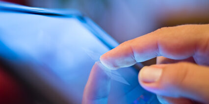 closeup of finger touching screen  on tablet-pc with shallow depth of field